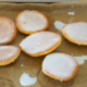 sechs Amerikaner frisch mit Zuckerglasur überzogen auf einem Blech mit Backpapier