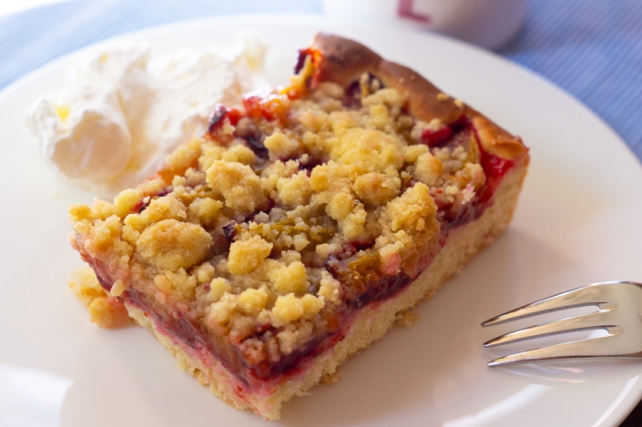 Stück Zwetschgenkuchen mit Hefeteig und Streuseln auf Teller
