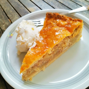 Stück gedeckter Apfelkuchen mit Sahne auf einem Teller