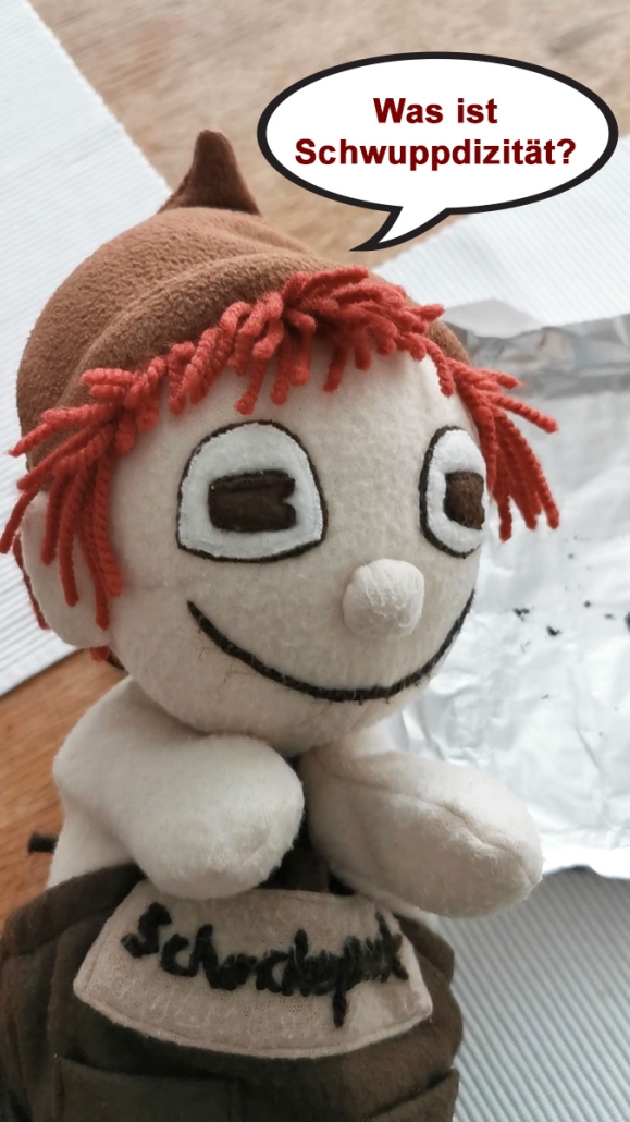 Handpuppe Schokopuck mit Sprechblase, in der steht: Was ist Schwuppdizität