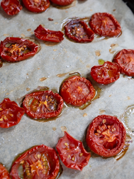 Scheiben von angetrockneten Tomaten auf Backpapier
