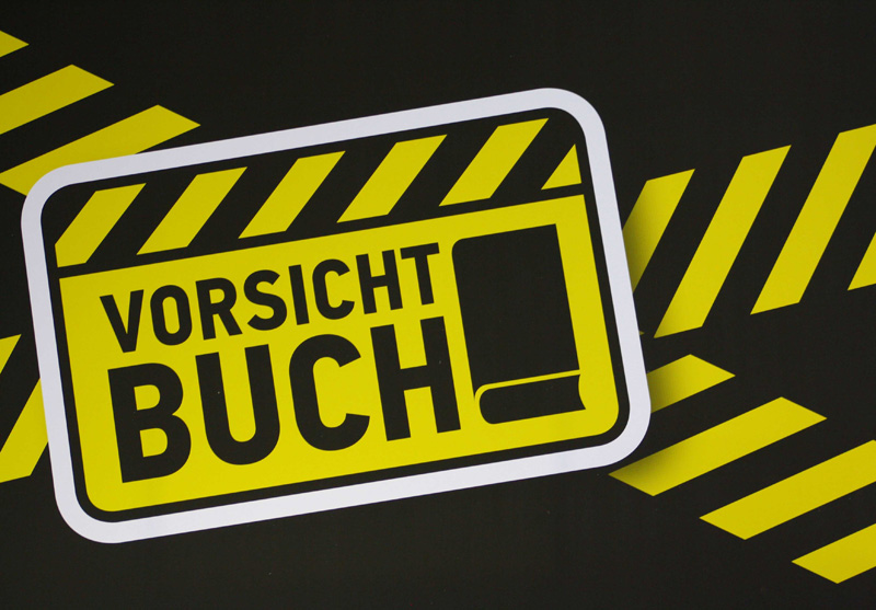 Schild auf der Buchmesse mit der Aufschrift Vorsicht Buch